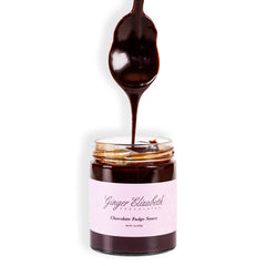 Ginger Elizabeth Chocolates Chocolate Fudge Sauce Jar with dipped spoon above on white background 