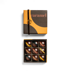 Ginger Elizabeth Chocolates Caramel Collection bonbons in box with lid  with g charm above  on white background