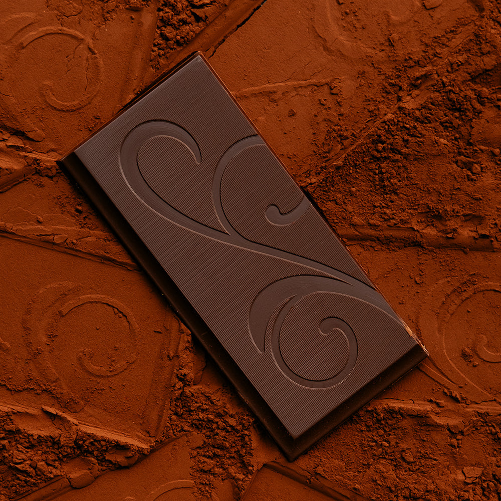 Chocolate bar with scroll detail on cocoa powder with impressions of decorative scroll detail.