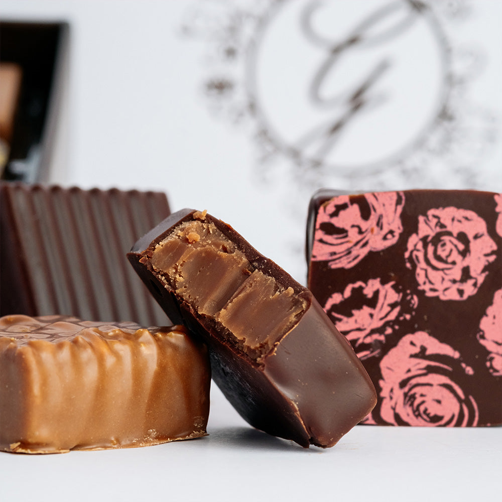 Close up of assorted chocolates with box blurred in background.