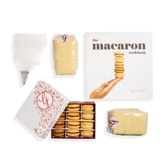 Ginger Elizabeth Chocolates Macaron Cookbook, 12 -piece assorted macaron box, 2 almond flour bags and pastry bag  with piping tip arranged on white background 