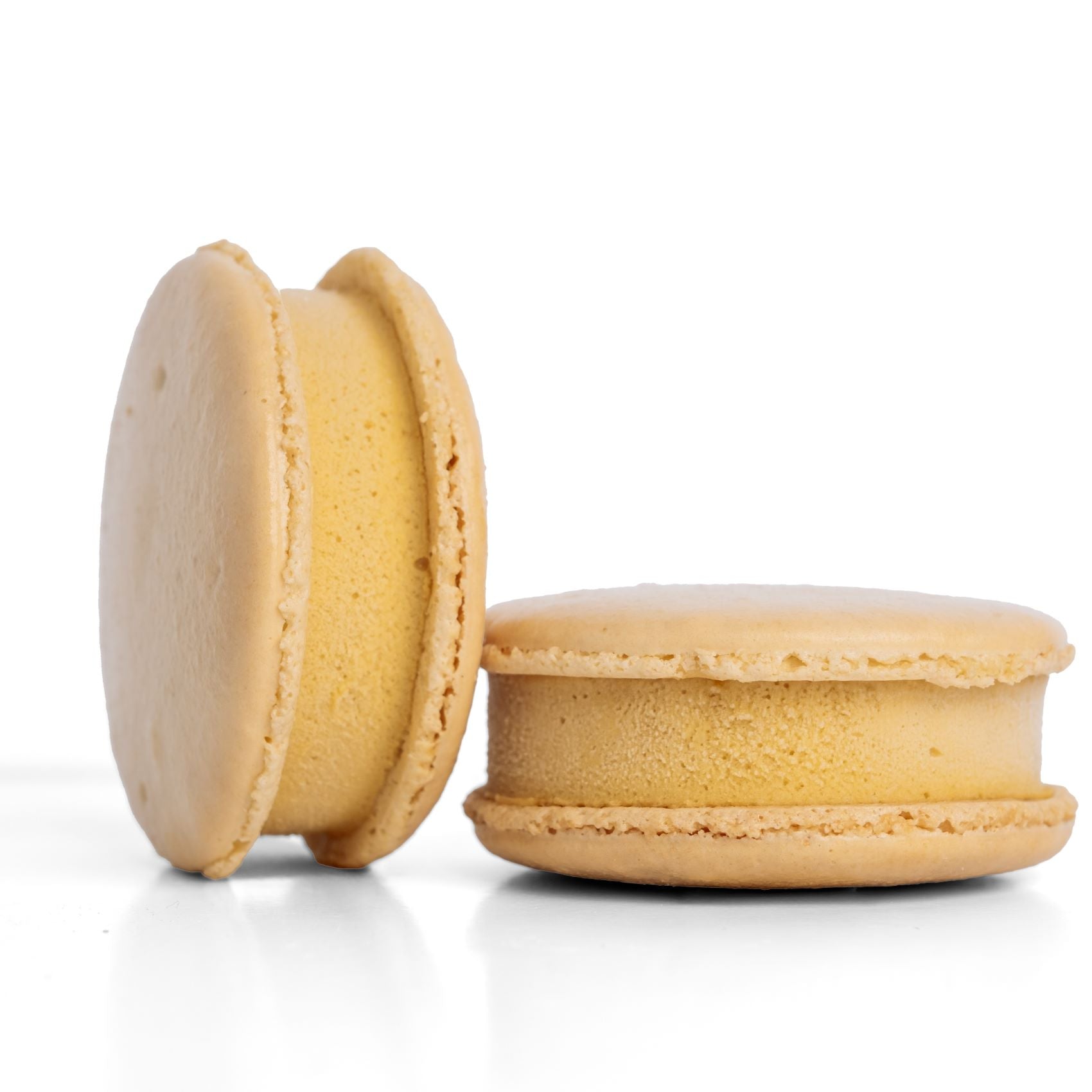 Two plain macaron ice cream sandwiches on a white background