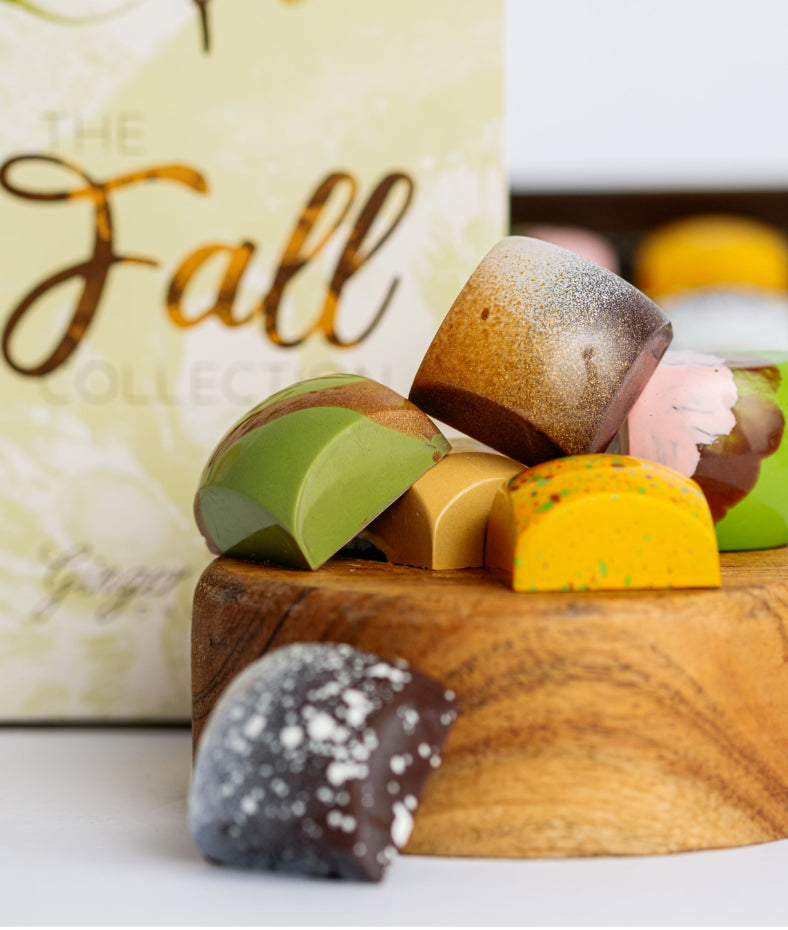 Assorted colorful candies on a wooden board with a 'Fall' themed background