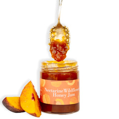 Ginger Elizabeth Chocolates Nectarine Wildflower Honey jam jar with fresh nectarine slices and dipped spoon on white background
