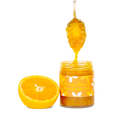 Ginger Elizabeth Chocolates Orange Blossom Marmalade Jelly Jar with orange half and dipped spoon on white background 