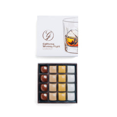 Ginger Elizabeth Chocolates California Whiskey Flight chocolates including 4 each Dark, Milk, Blond  and White Whiskey bonbons in open box with lid featuring hand drawn Whiskey glass above on white background 