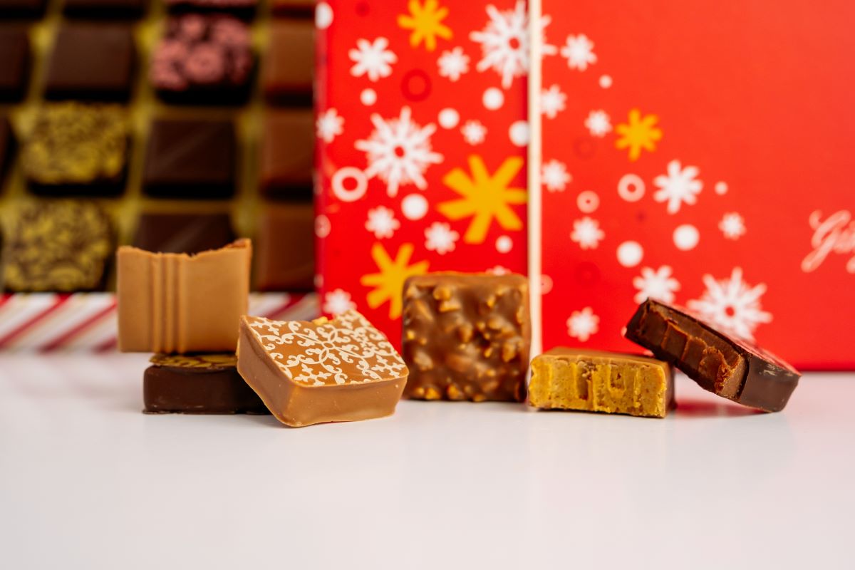 Close up of Ginger Elizabeth 24 piece chocolates in foreground with open and closed boxes blurred in the background