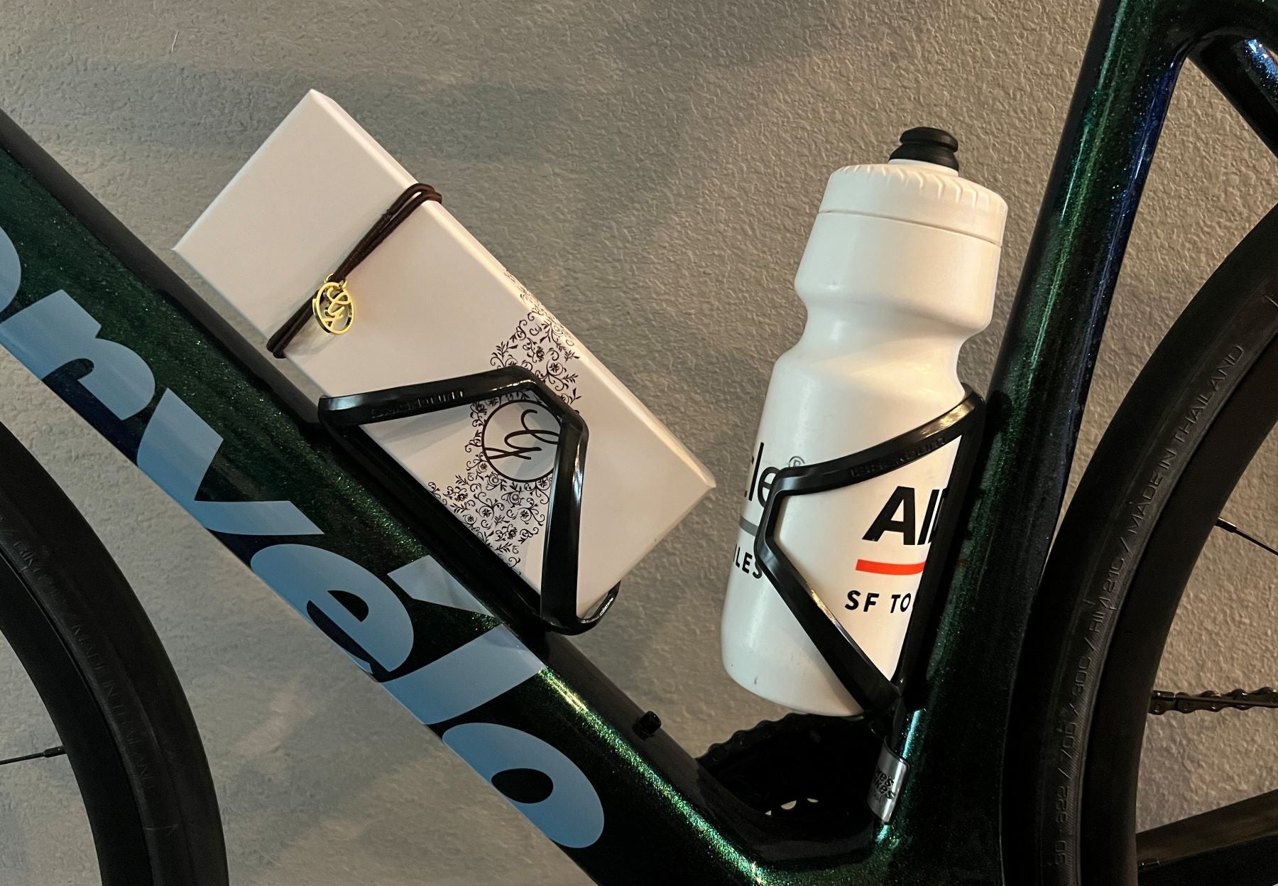 cropped image of a 12 piece chocolate box and a water bottle in black racing bike water bottle holders