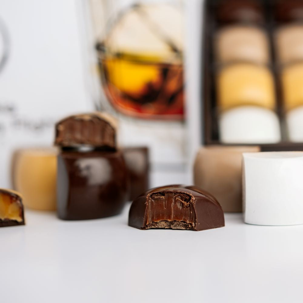 close up of whiskey collection chocolates with box in background