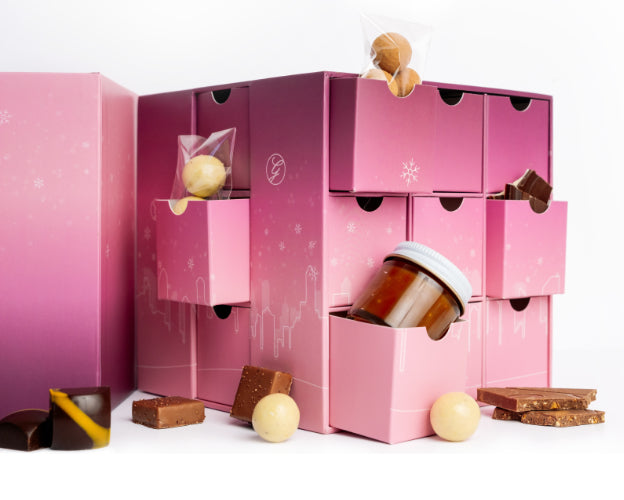 Pink chocolate advent calendar with various chocolates on a white background