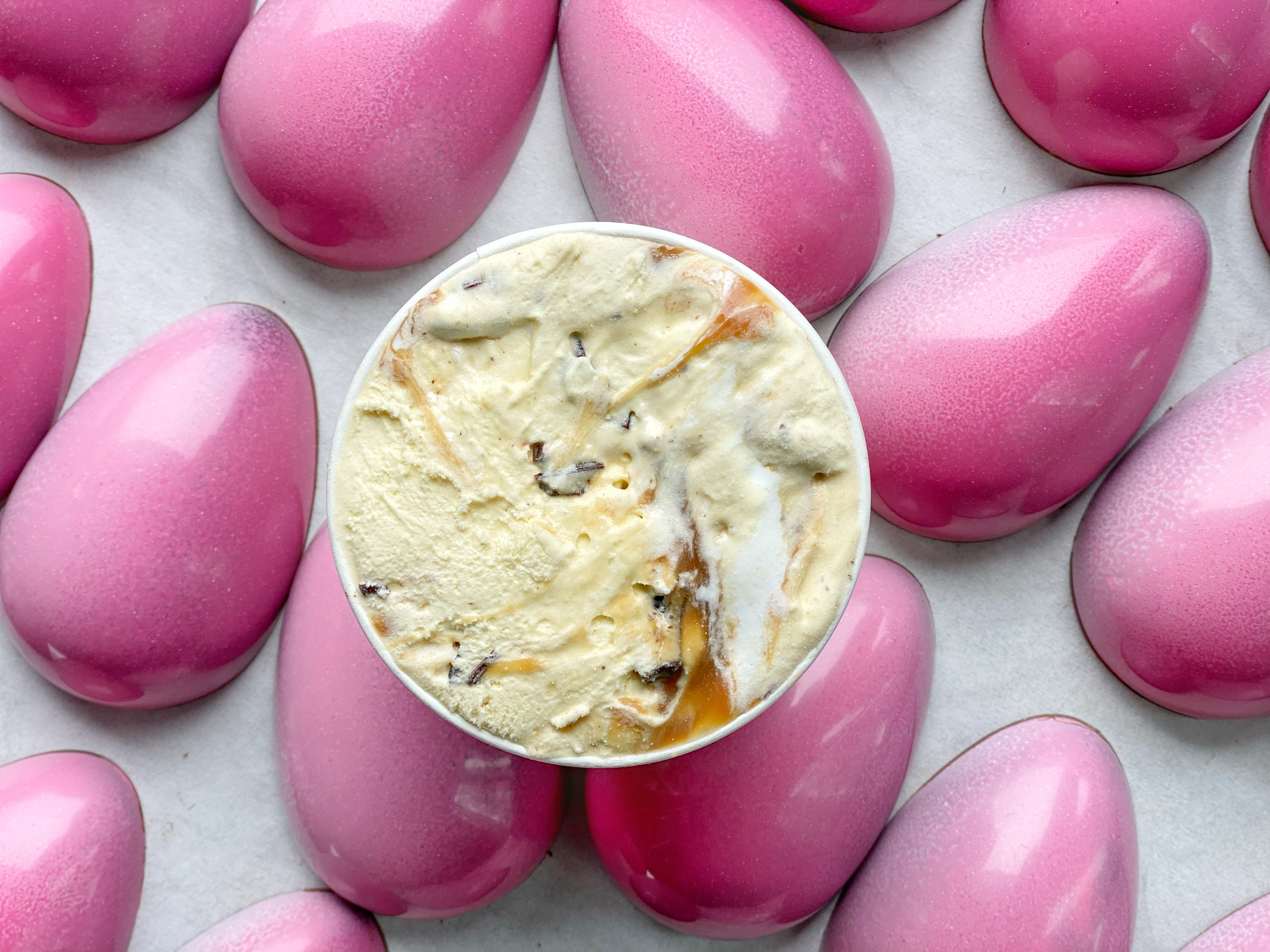 Caramel Marshmallow Chocolate Egg Ice Cream Pint shown with Pink Caramel Marshmallow Chocolate Eggs