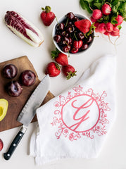 Ginger Elizabeth Chocolates logo  tea towel displayed with pink and red fruits  cutting board and knife.